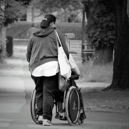 black-and-white woman pushing wheelchair